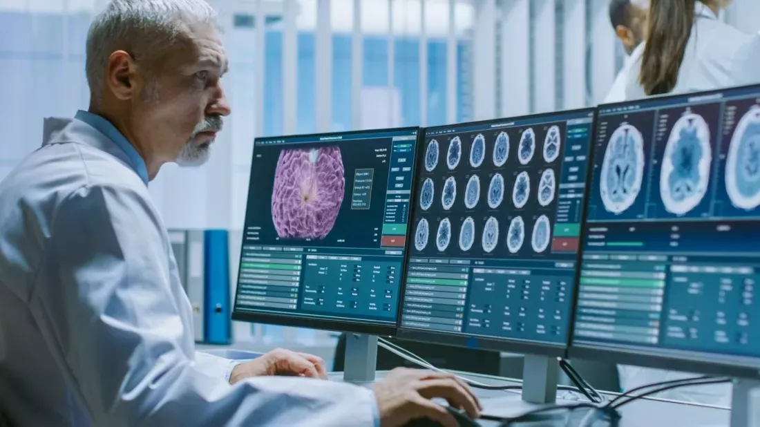 Un scientifique observe une image du cerveau sur un grand ecran dans un laboratoire.